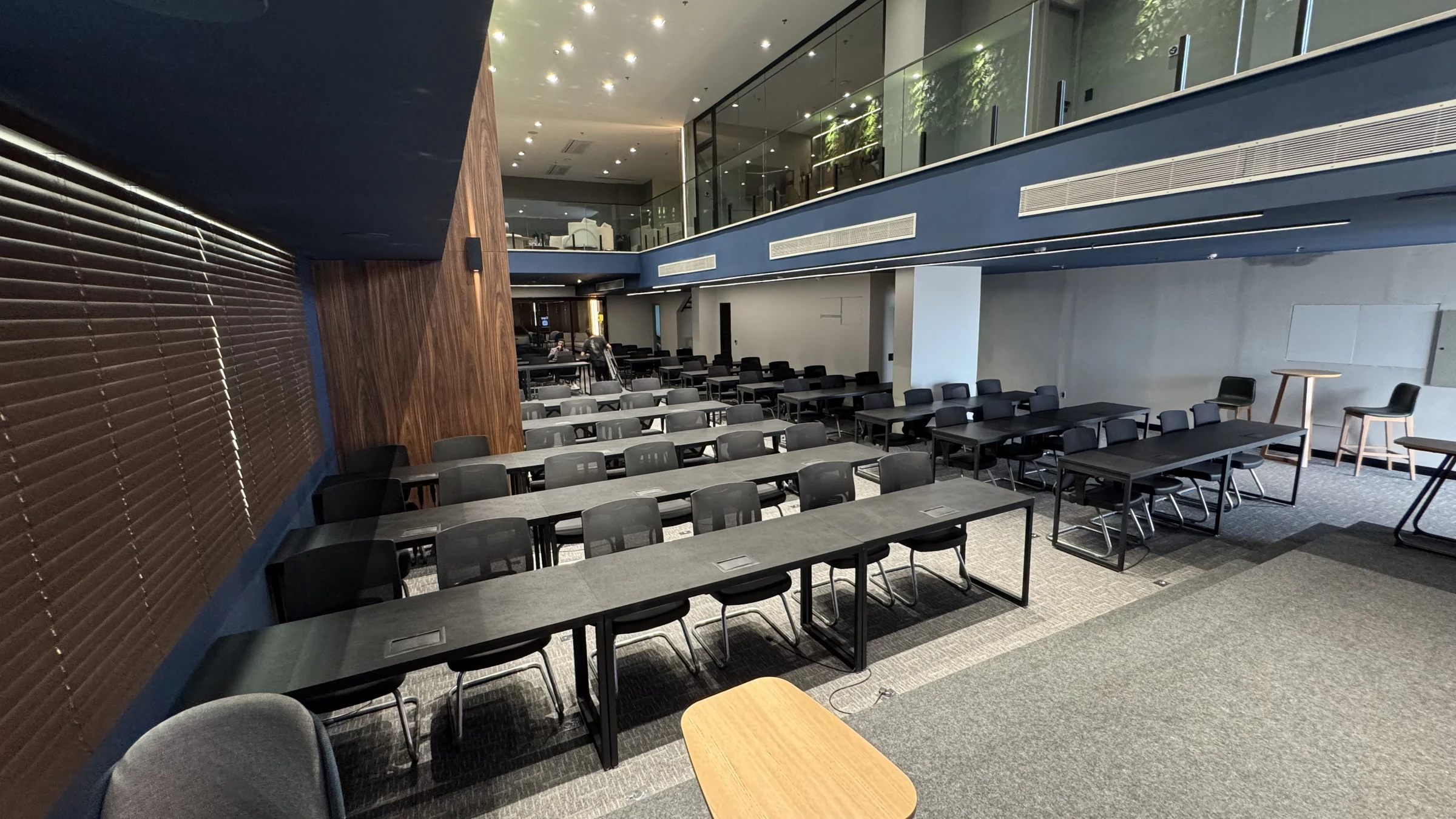 Salão principal da sede Enjoy Business com mezanino e mesas